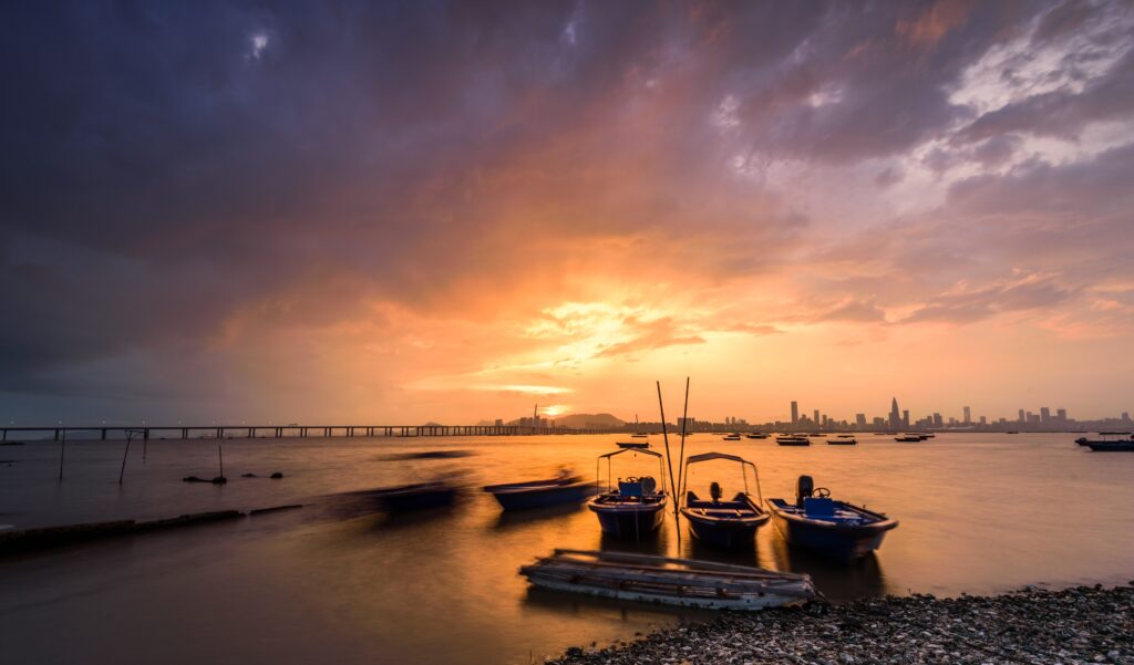 motorboats parked on the water by the water with sunset and a city visible in the background